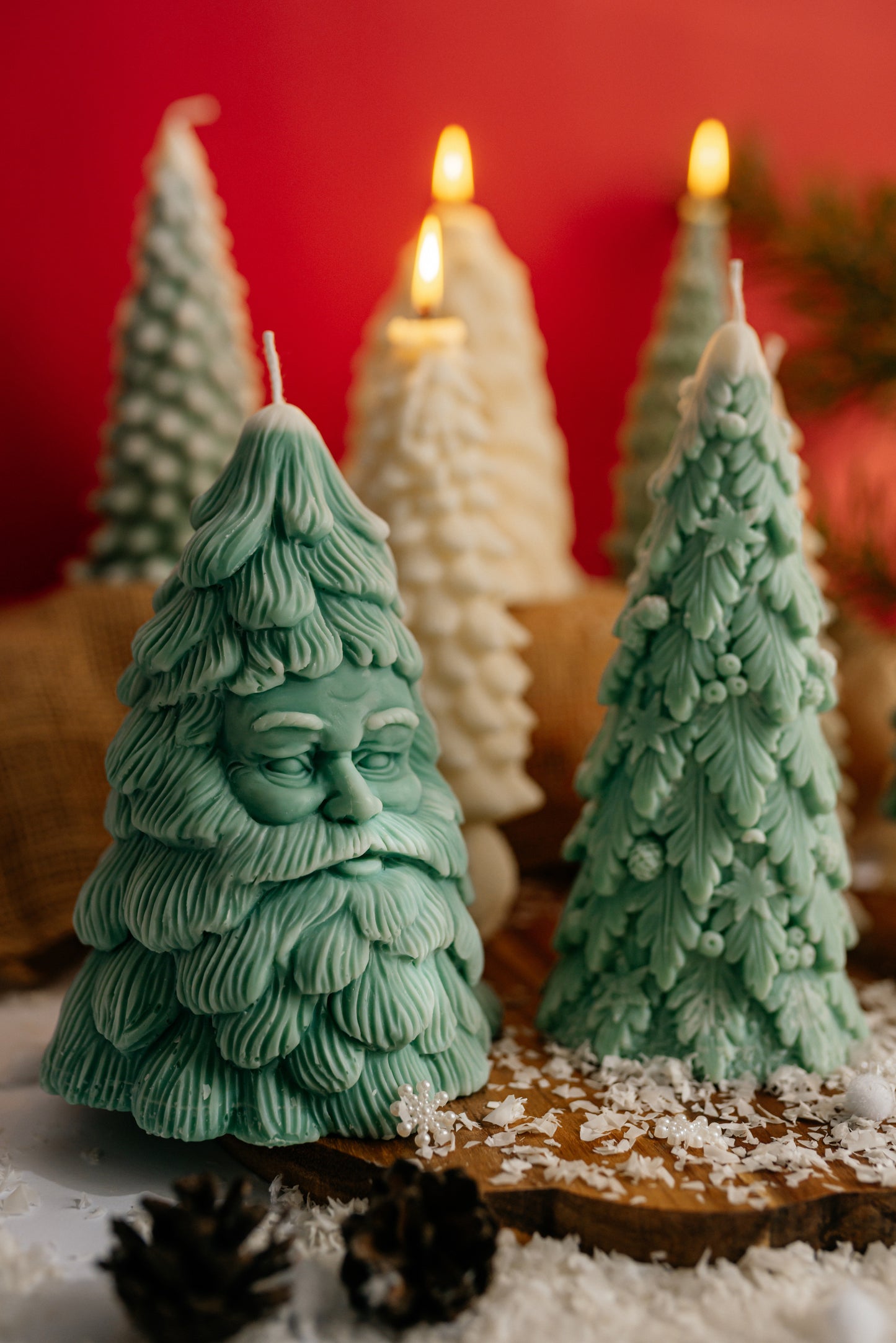 Green Christmas tree candle shaped like Santa Claus face with textured pine details and festive background.
