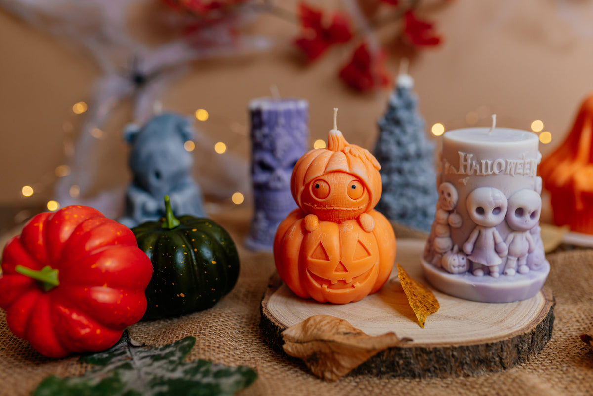Spooky Halloween candle set on a wooden slice with mini pumpkins.