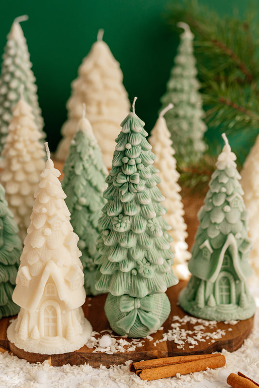 Green soy wax candle shaped like a Christmas tree decorated with bows and ribbons, standing on a round gift-sack base.